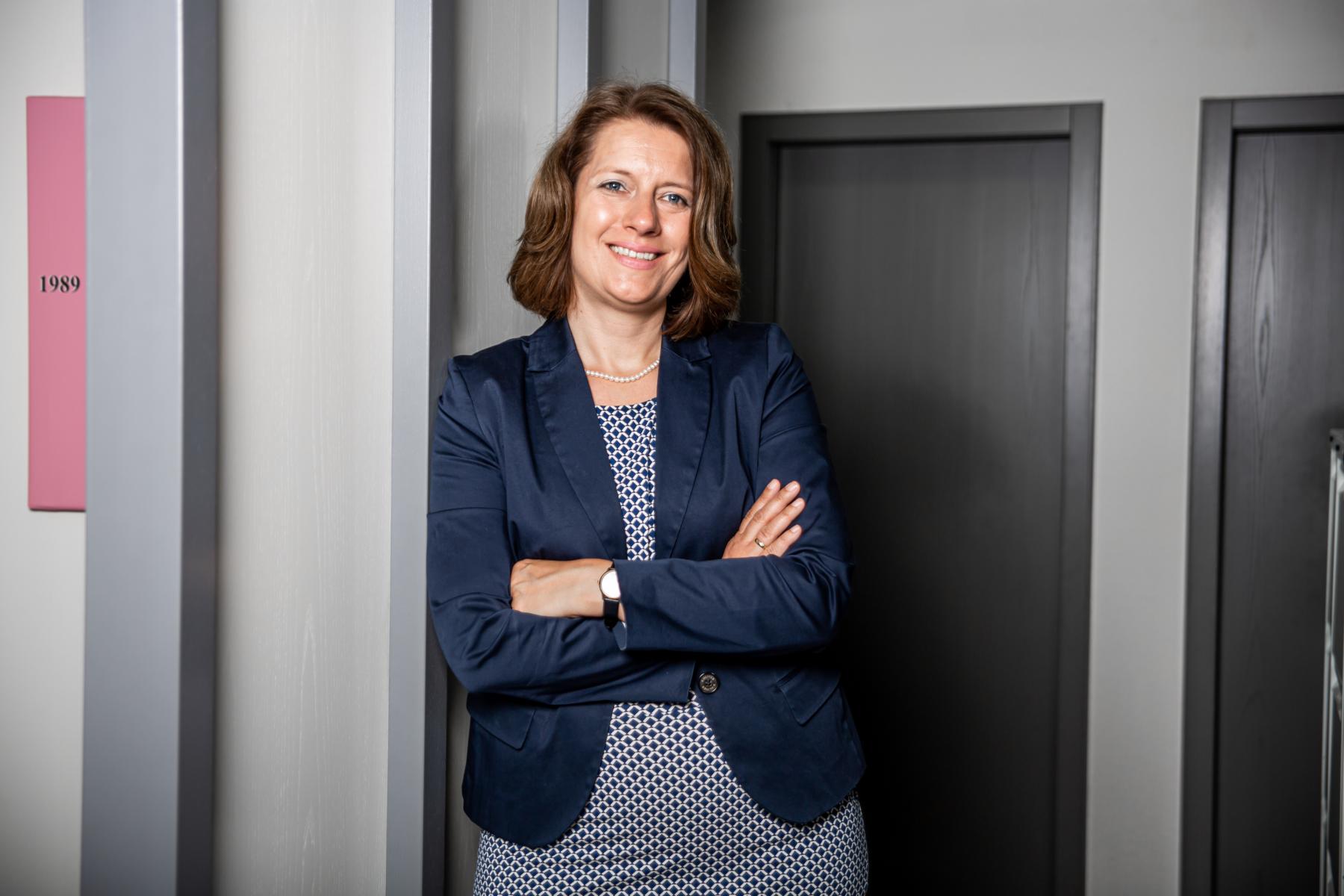Kerstin Nader, Steuerberaterin, steht mit verschränkten Armen lächelnd im Flur der Kanzlei